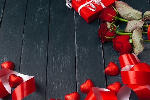 St. Valentines Day. Red roses and gift box on wooden table