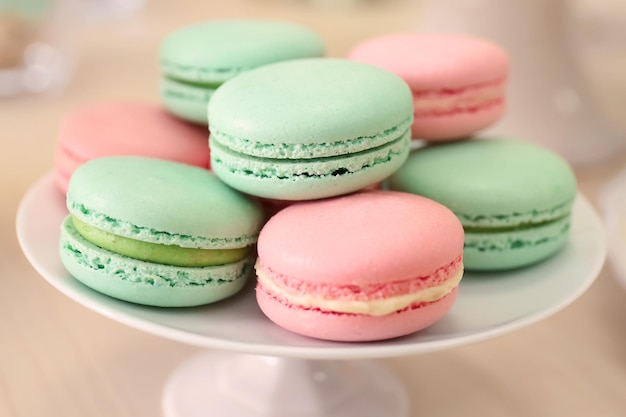 Sta met smakelijke macarons op tafel.