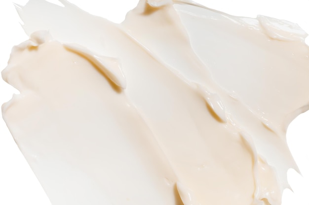 Foto staal van beige crème textuurcosmetica voor gezicht en lichaam op een geïsoleerde achtergrond druppel uitstrijkje