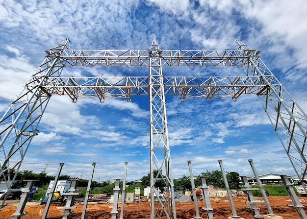 Foto staalstructuur van hoogspanningsstarttoren en schakelwerf op de blauwe hemelachtergrond