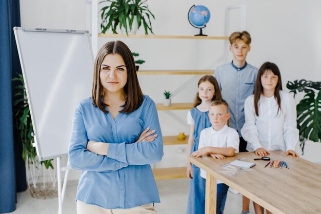 Staan en poseren Samen lachen Groep kinderen van verschillende leeftijden staan in een ruim klaslokaal op school met leraar