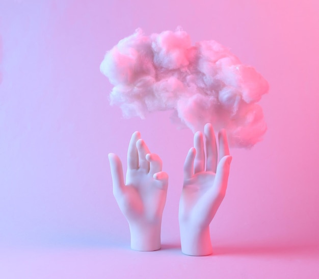 Staan handen en zwevende pluizige wolk in blauw roze neon verlooplicht Creatief idee Concept art Minimalisme Surrealisme