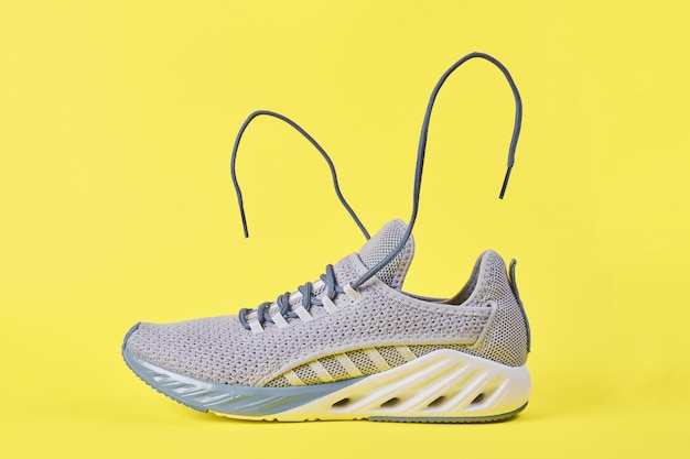 Stability and cushion running shoes New unbranded running sneaker or trainer on yellow background