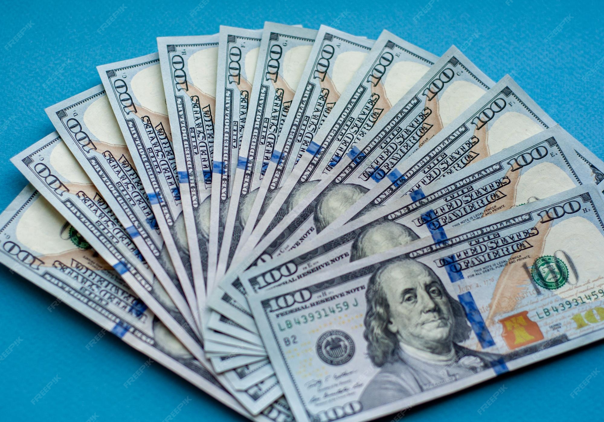 premium-photo-stack-of-100-dollar-bills-blue-background-fan-of