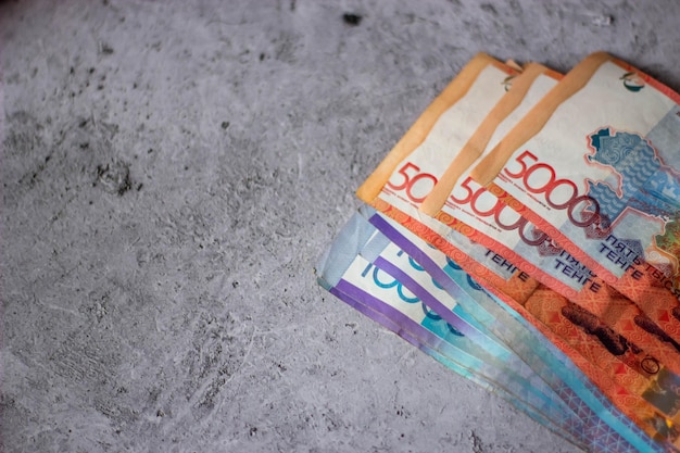 A stack of 100 euro banknotes on a gray surface.