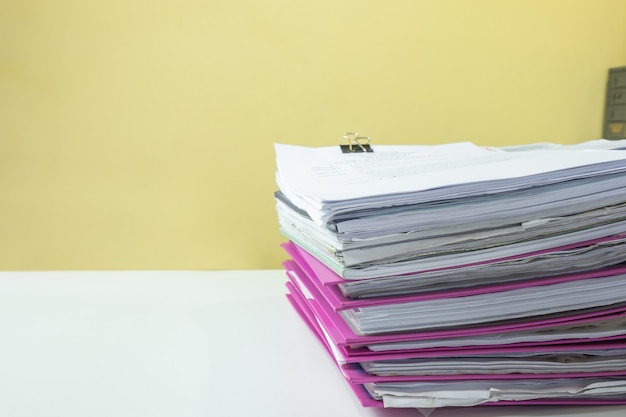 Stack of accounting documents on white desk in office