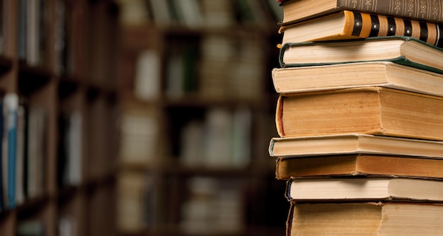 Photo the stack ancient books on a library background