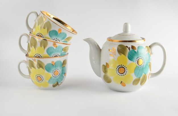 Stack of antique ceramic cups, teapot