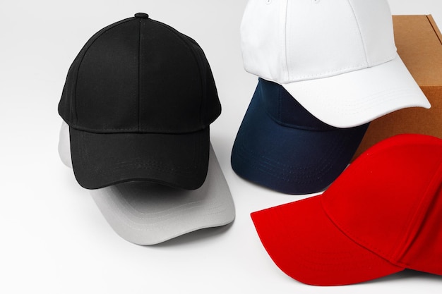 Stack of assorted baseball caps on a white background