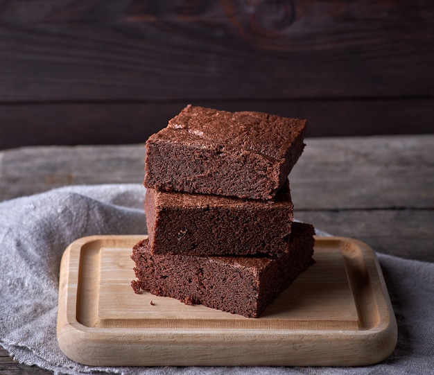 Stack of baked square pieces of chocolate brownie cake 