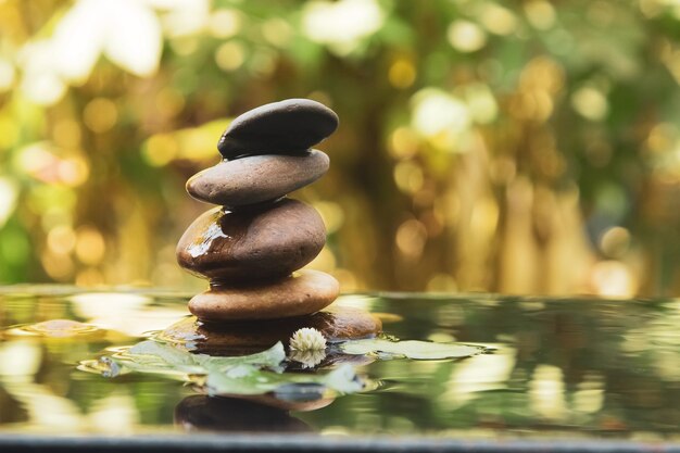 Foto pila di pietre equilibrate piramide sull'acqua con luce dorata concetti di pace naturale