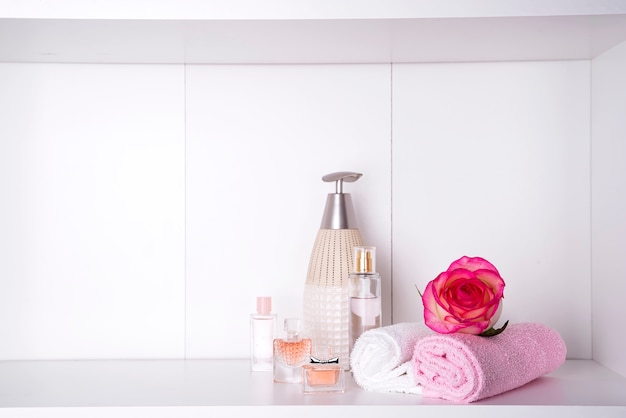 Stack of bath towels with rose on light background