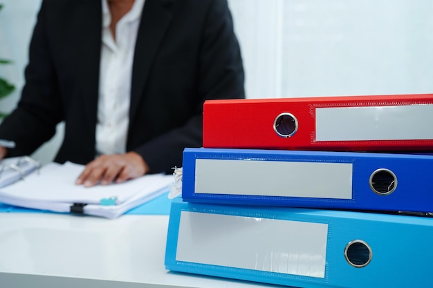 Stack of binder file folder on table in business modern officexAon wooden desk in large modern office