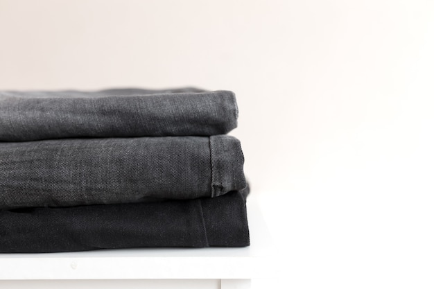 A stack of black denim jean pants.