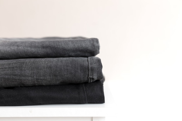 Una pila di pantaloni di jeans in denim nero.