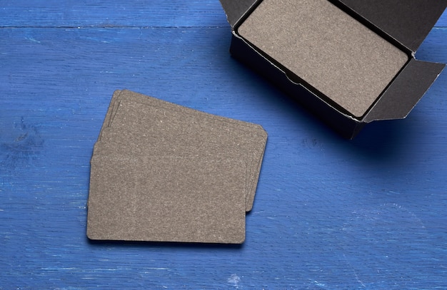 Stack of black paper business cards on blue wooden space