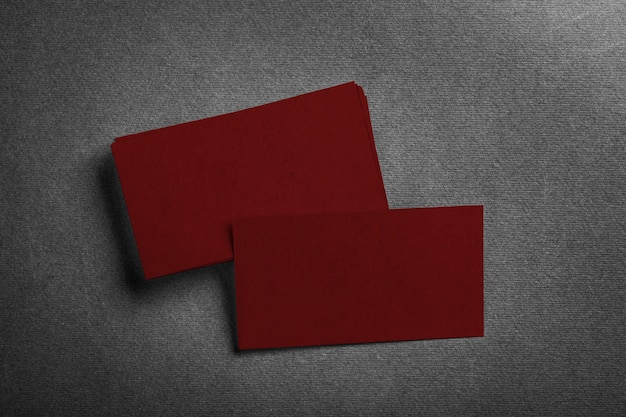 Stack of blank dark red business card on grey textured top view