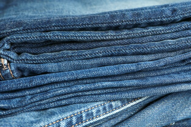 Stack of blue jeans as background, space for text