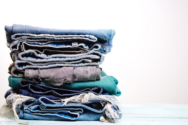 Stack of blue jeans on white background