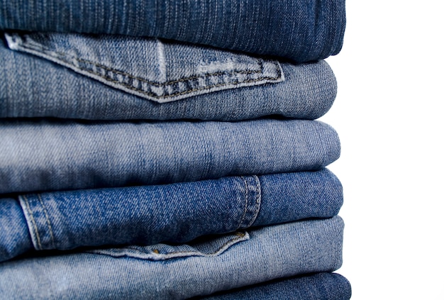 Stack of blue jeans over white