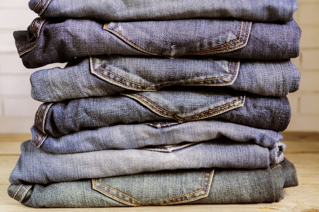 Stack of blue jeans on wooden shelf. Beauty and fashion clothing concept