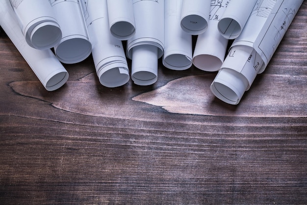 Stack of blueprint rolls on pine wooden vintage board maintenance concept