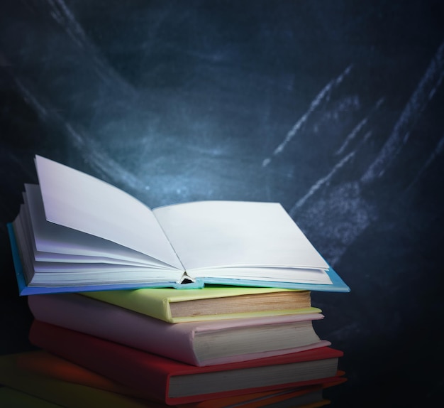 Stack of books against the background of the teachers' board