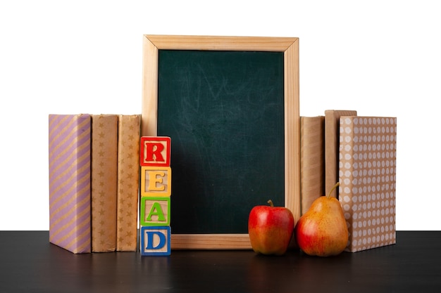 Stack of books and apple on tabletop against white background