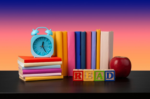 Photo stack of books on black wooden table, close up