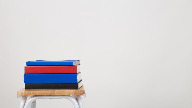 A stack of books on a chair. Isolated a white background.