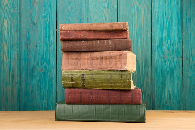 Photo stack of books on the desk over wooden background