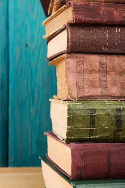 Stack of books on the desk over wooden background