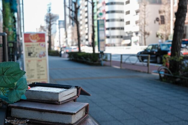 Stack of books on footpath by street
