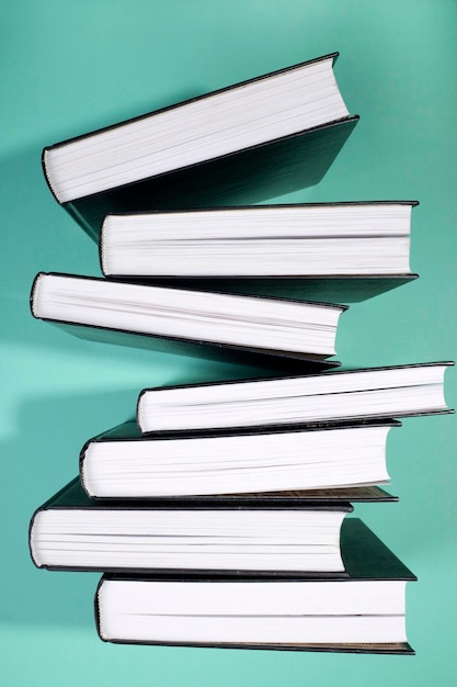 A stack of books on a green background side view