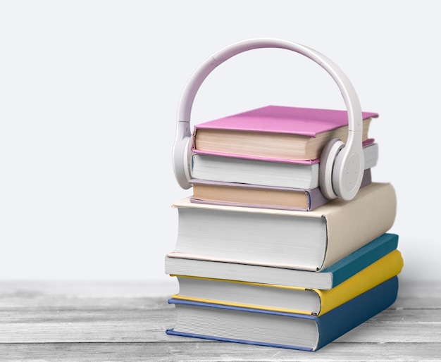 Stack of Books and headphones on wooden table