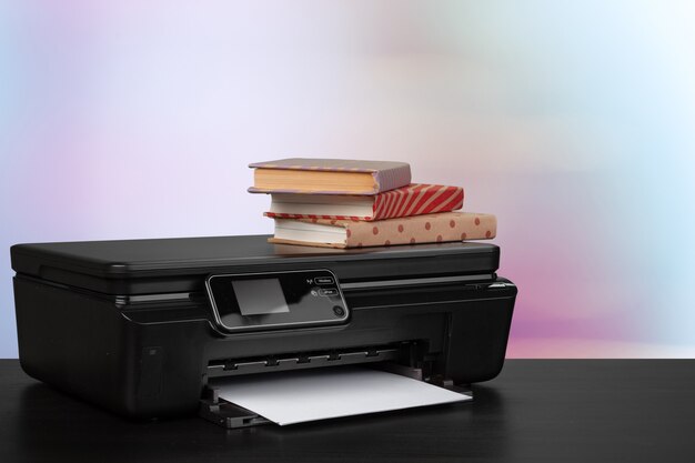 Stack of books and home printer against blurred background