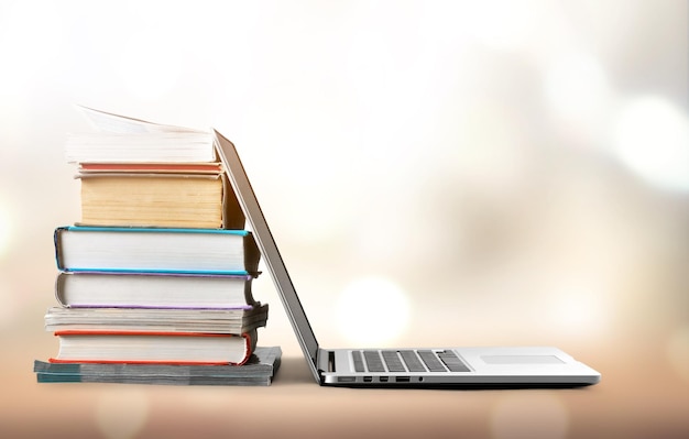 Photo stack of books and laptop modern education background