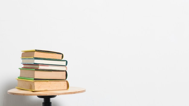 Stack of books on stool table on gray background 