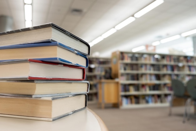 Photo stack of books on table at library