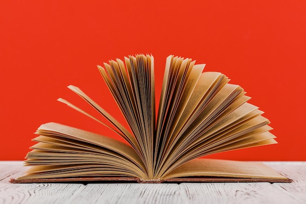 A stack of books on a white table on a red background