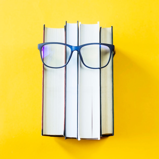 A stack of books with glasses is an image of a person's face