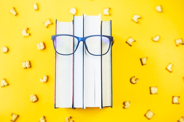 A stack of books with glasses is an image of a person's face
