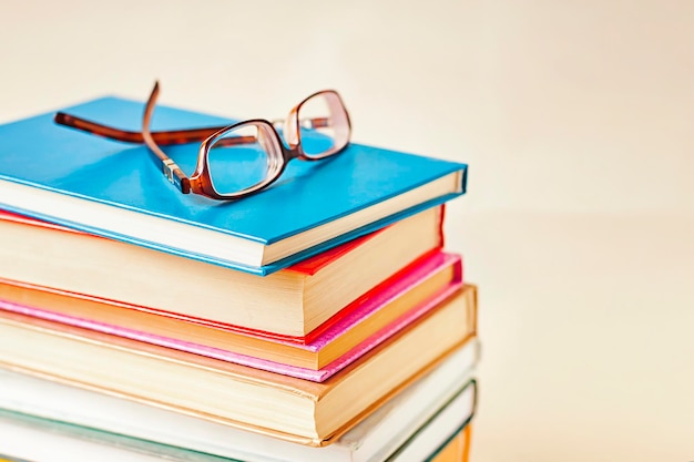 A stack of books with glasses on top of them