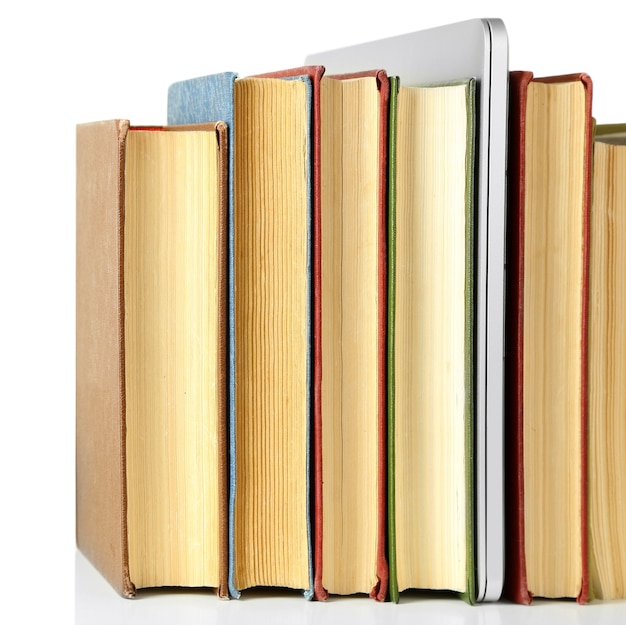 Stack of books with laptop isolated on white