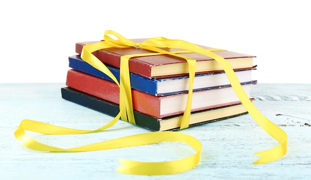 Foto pila di libri con il nastro sul tavolo isolato su bianco