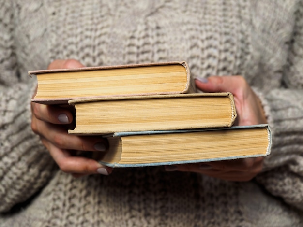 A stack of books in woman's hands