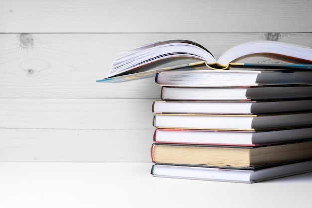 A stack of books on a wooden background.