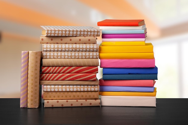 Stack of books on wooden table against blurred background