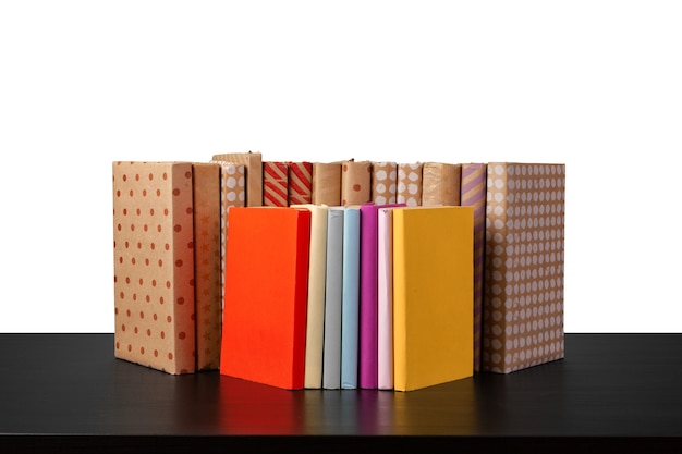 Stack of books on wooden table against white background