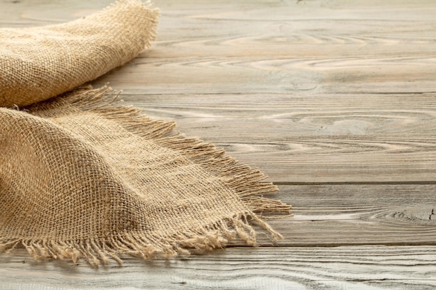 Stack of burlap napkins with fringe on wooden table closeup rustic style